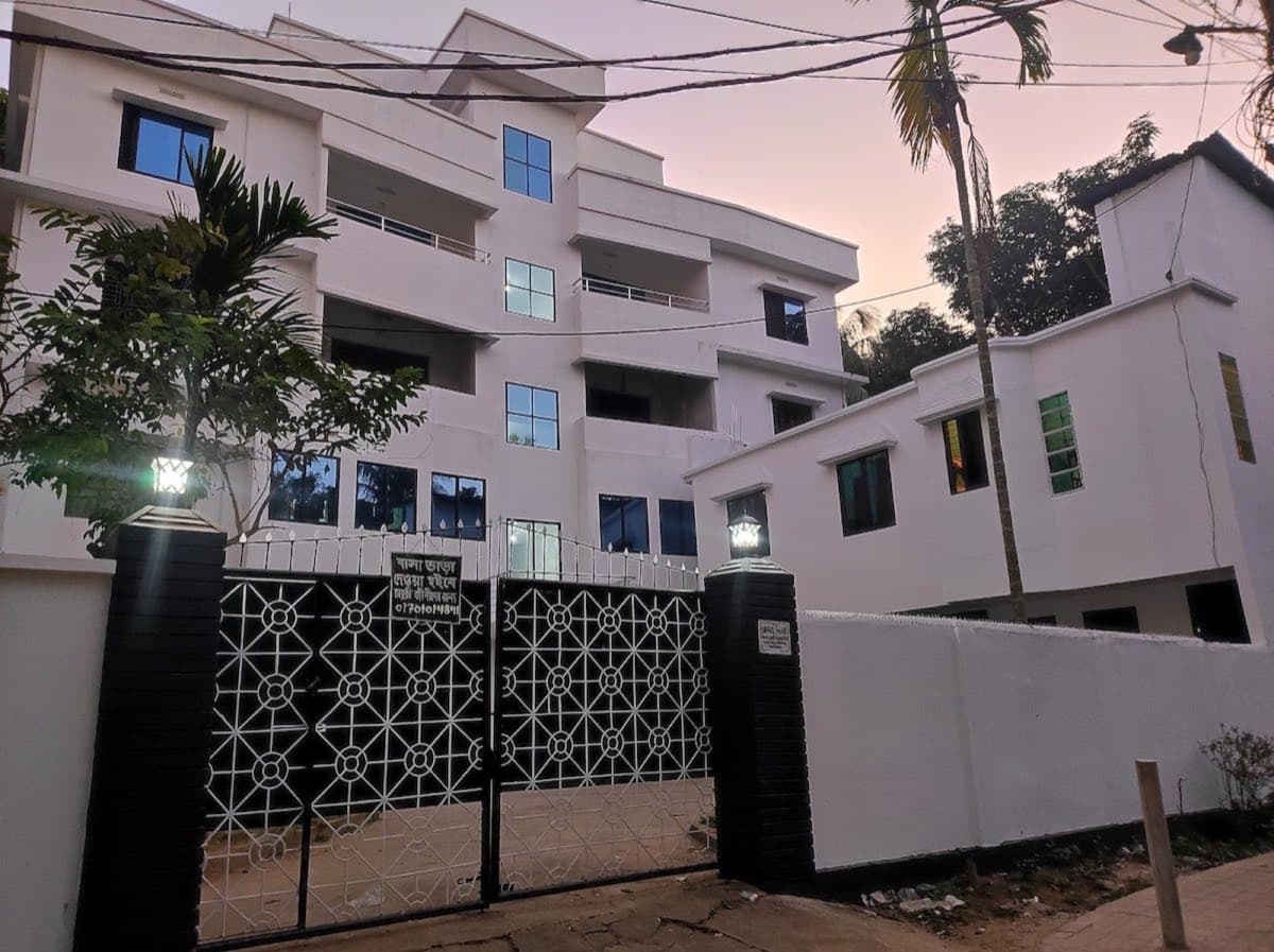 Arzu Villa Flat 8's apartment building exterior at dusk in Moulvibazar