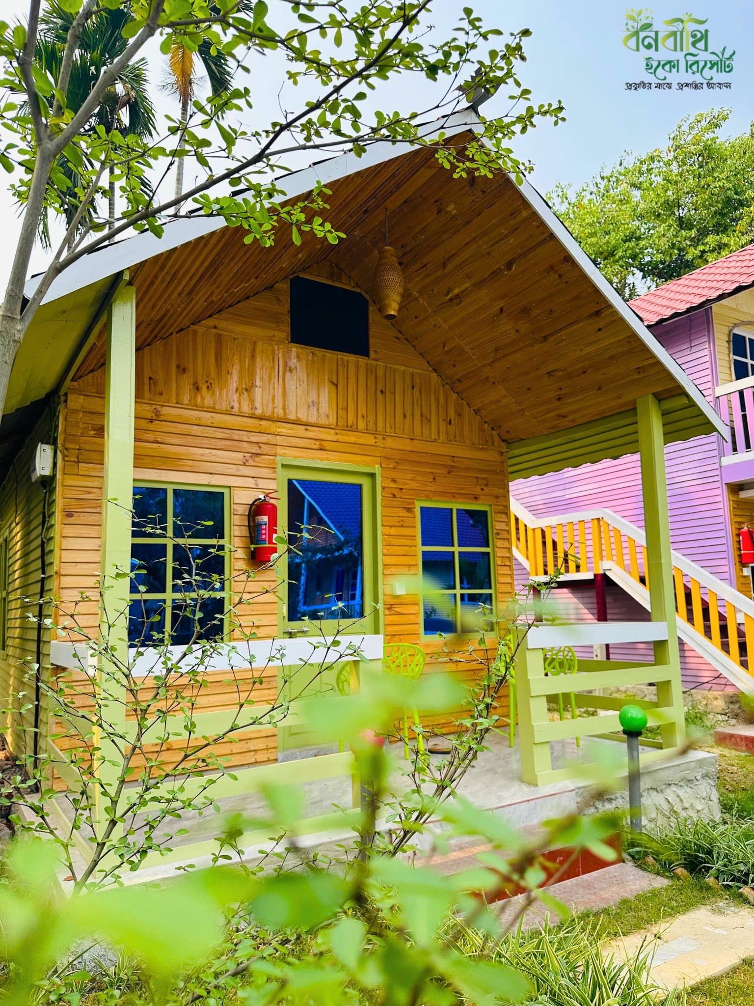 Couple Cottage 102 exterior at Banabithi Eco Resort, a wooden cottage with green trim and porch
