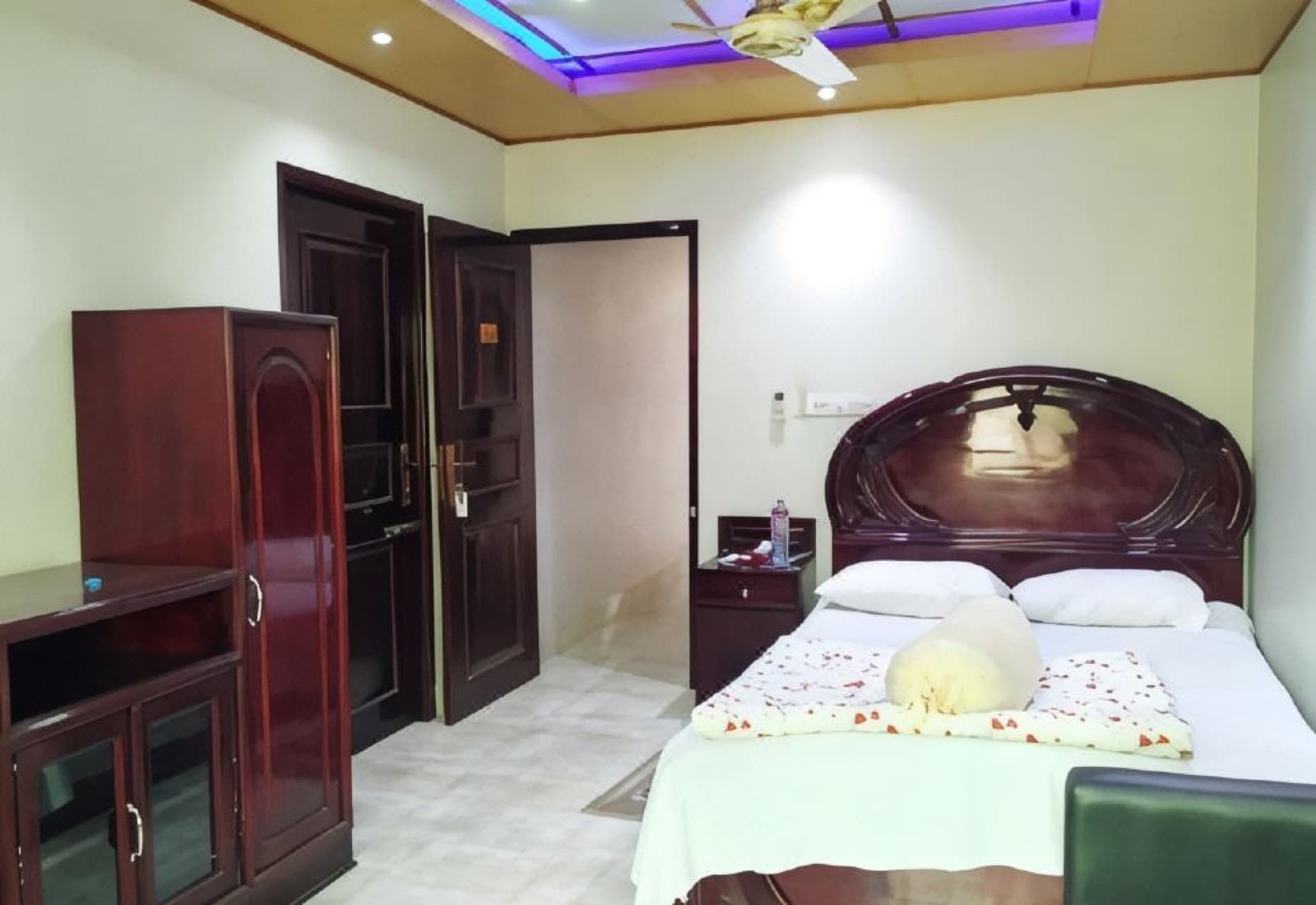 A double bedroom with dark wood furniture at Hotel Mohsin Plaza