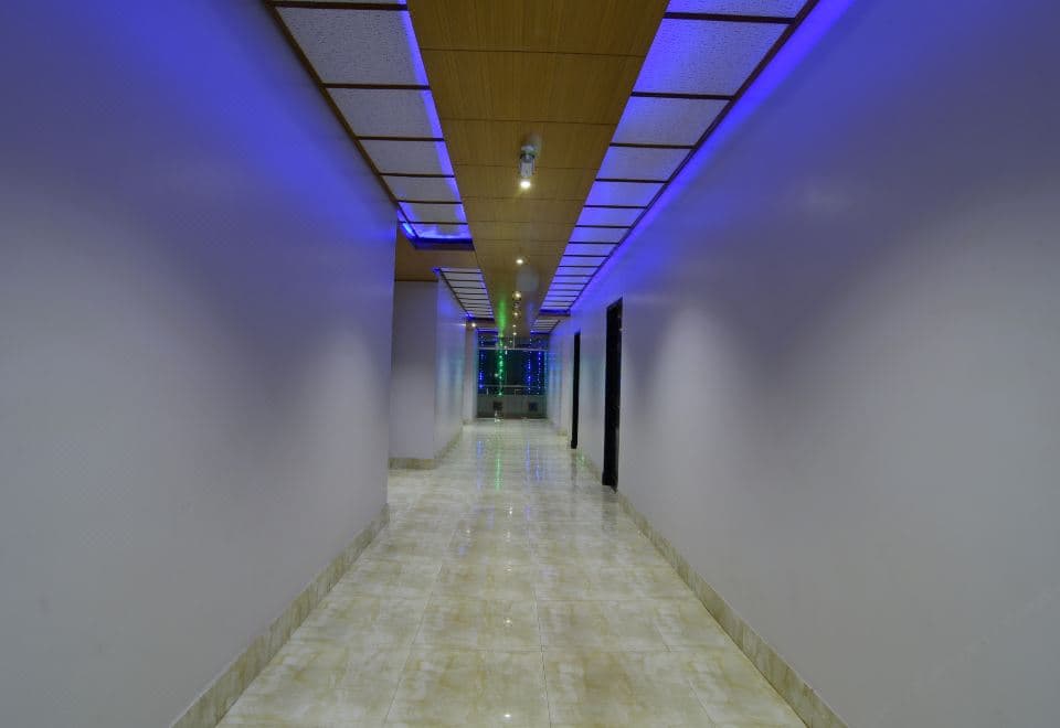 Hotel Mohsin Plaza's corridor lit with blue LED strip lighting along a wood-panelled ceiling