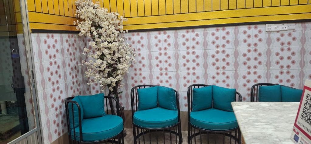 A seating area at Rose Inn with teal armchairs around a marble-topped table