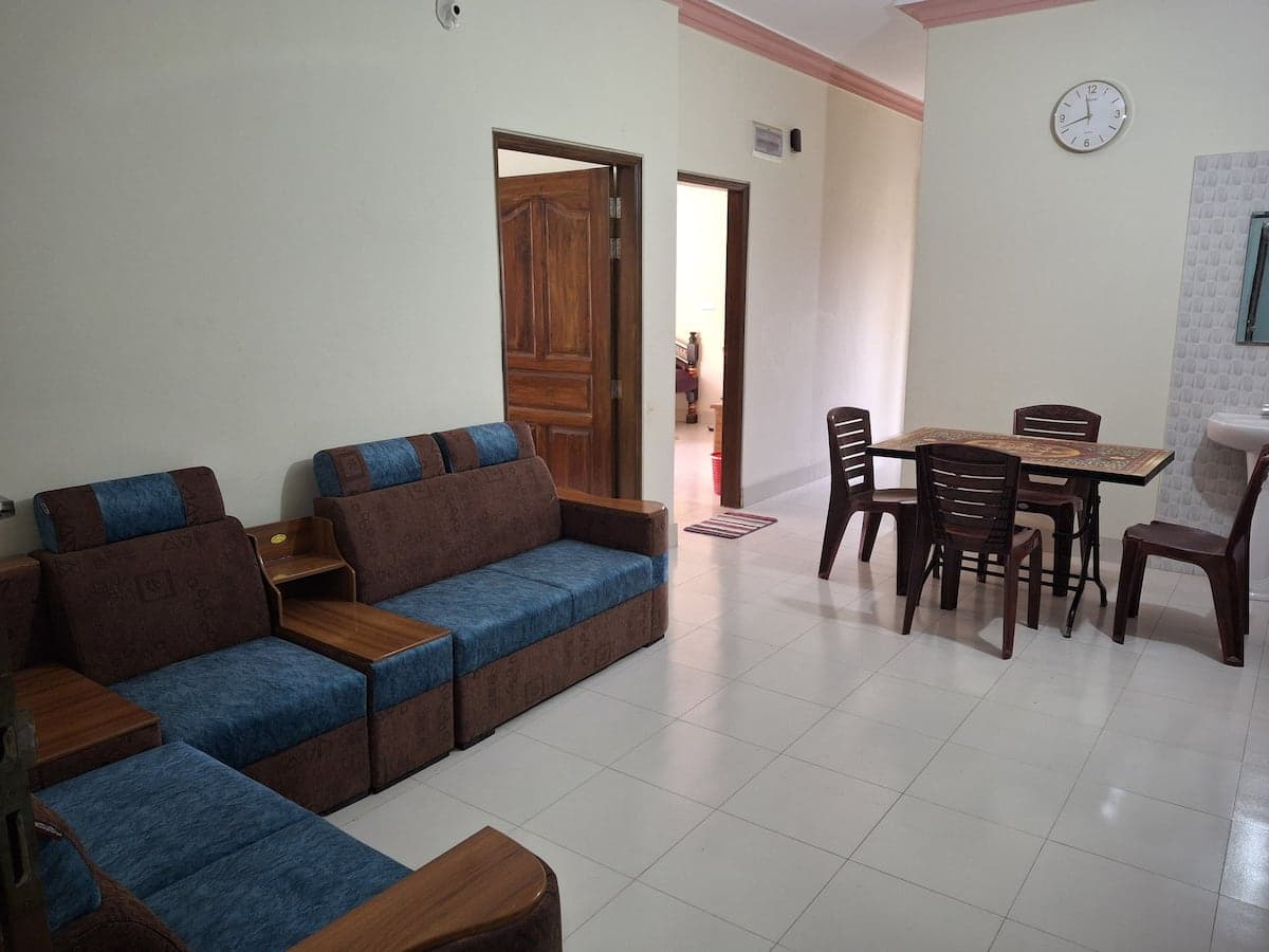 Open-plan living and dining area with blue sofa set and wooden dining table