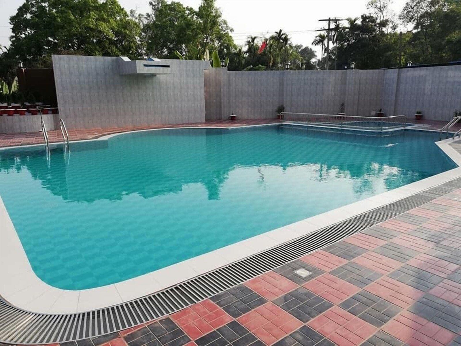 SKD Amar Bari's outdoor swimming pool with a tiled deck