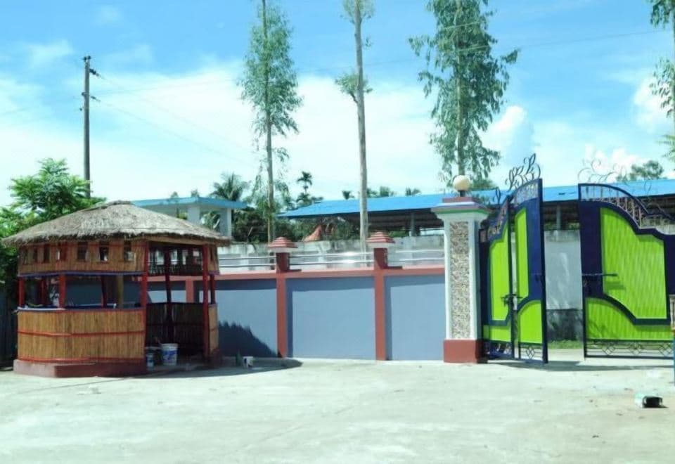 Tamim Resort's front entrance gate and a thatched-roof bamboo gazebo within the grounds