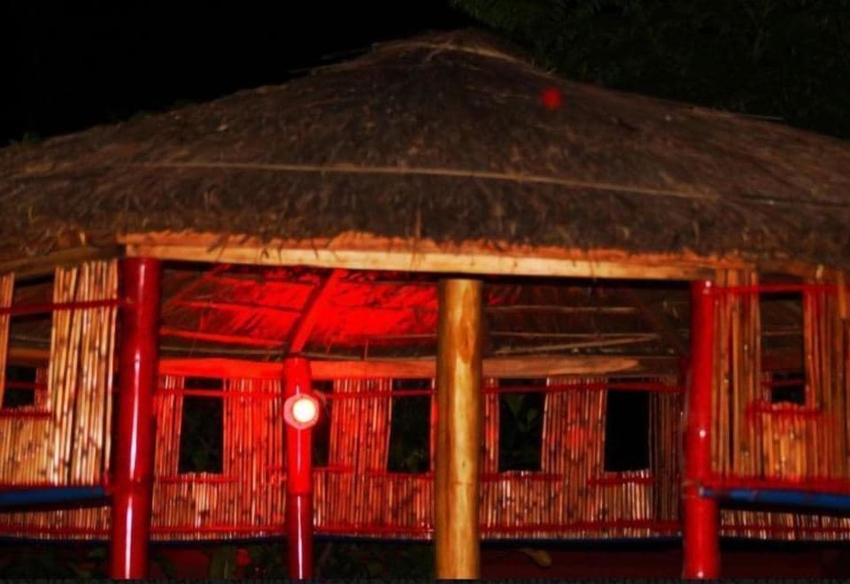 A bamboo-and-thatch gazebo on the grounds of Tamim Resort, lit red at night