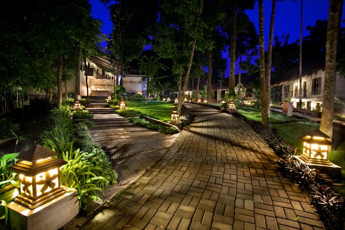 A lantern-lit stone walkway through the forest connecting DuSai Resort & Spa's villa buildings at night